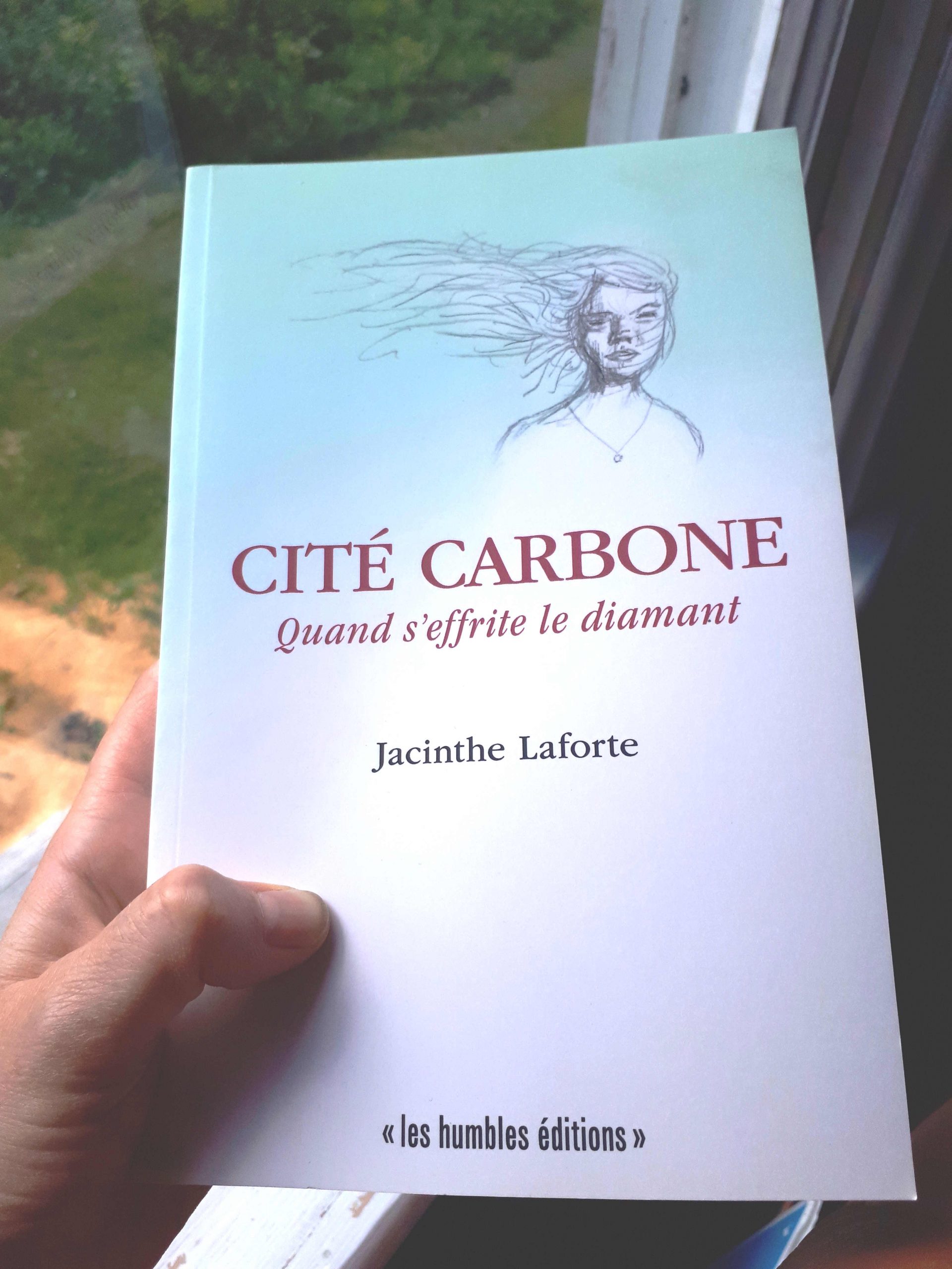 Livre papier Cité carbone de Jacinthe Laforte tenu dans une main